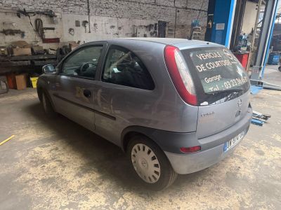 une petite voiture garée dans un garage, avec une pancarte à l'arrière