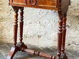 a small wooden table with a drawer on top of it