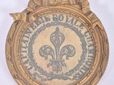 an image of a gold plaque with a fleur de lis on it