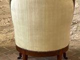 an upholstered chair with wooden legs and a beige upholstered seat