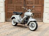 a scooter that is parked in front of a wooden door