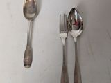 two spoons and a fork sitting on a table