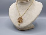 un collier en or avec un pendentif en forme de fleur sur un mannequin