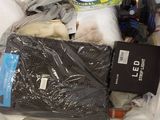 many items that are in a plastic bag on the bed