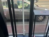 un parcmètre devant une fenêtre, avec une voiture en arrière-plan