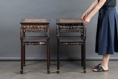 a woman that is standing next to two tables
