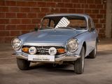a silver car that is parked in front of a brick wall