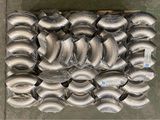 a large pile of metal pipes and fittings on a pallet