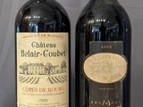 two bottles of wine sitting on a wooden table