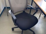 a desk with a chair and a computer on it