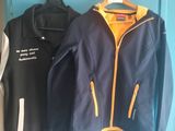 two jackets that are hanging on a blue door