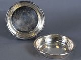 a pair of silver plated dishes on a grey background