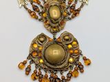 an image of a necklace with a gold and brown beaded design