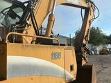 une pelleteuse jaune qui est à l'arrêt dans la terre