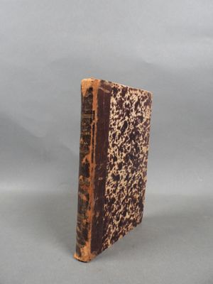 an old book sitting on top of a gray surface