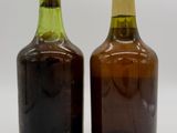 two brown and green bottles sitting next to each other on a white surface
