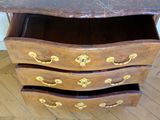 a wooden chest of drawers with a marble top