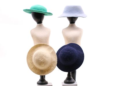 trois chapeaux posés sur une tête de mannequin