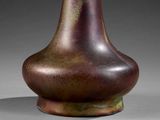 a brown vase sitting on a table with a gray background