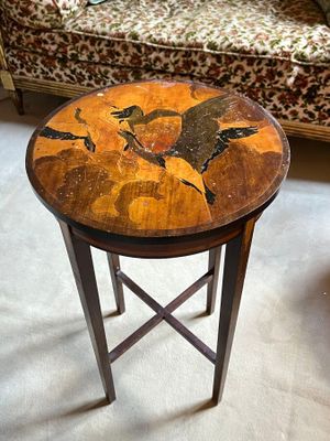 a small table with a painting on it in a living room