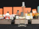 several bottles of perfume are lined up on a black table