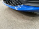 a close up of a blue car parked in a parking lot