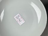 a person holding a white bowl with a sticker on it