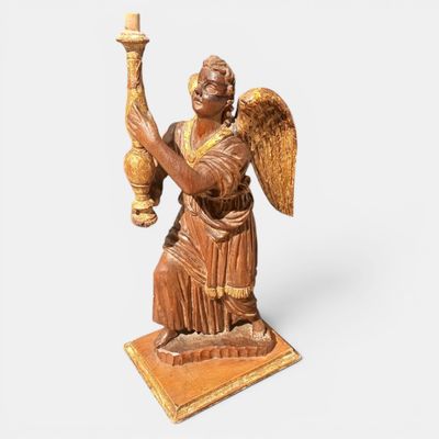 une image représentant une statue d'un ange tenant une bougie
