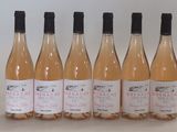 six bouteilles de vin sont alignées sur une table