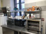a small kitchen with a refrigerator, microwave, and other appliances