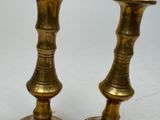 two brass candlesticks that are sitting on a table