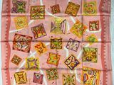une écharpe rose sur laquelle est représenté un lot de timbres