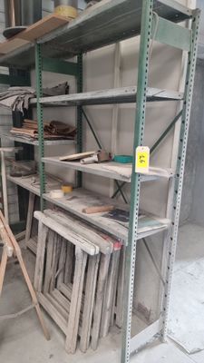 de nombreuses étagères qui se trouvent dans un garage et sur lesquelles sont posés des outils