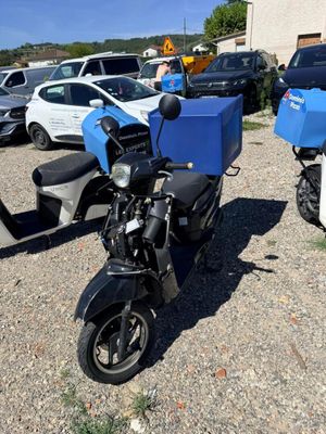 un scooter garé dans un parking avec d'autres scooters