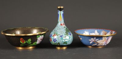 three bowls and a bottle sitting next to each other on a table