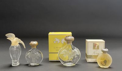 three glass perfume bottles and a box of perfume on a table