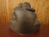 a statue of a man sitting on top of a wooden table