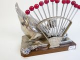 une sculpture en argent représentant un oiseau orné de perles rouges