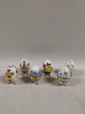 four miniature porcelain eggs with flowers and birds on them