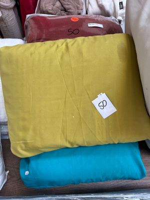 several pillows are stacked on top of each other in a store