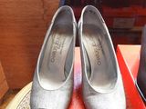 pair of silver shoes sitting on top of a table next to a pair of shoes