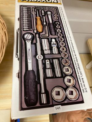 une boîte à outils posée sur une table, avec un panier à l'arrière-plan
