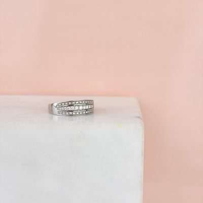 un gros plan d'une bague en diamant posée sur un bloc de marbre blanc