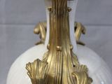 a white and gold vase with a gold decoration on it