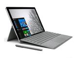 un ordinateur portable Microsoft Surface avec un stylet posé dessus, à côté d'une tablette