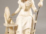 statue of a woman with a bird on her arm and a bird on a chair