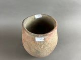 a small vase with a tag on it sitting on a table