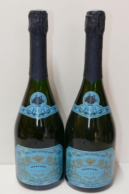 two bottles of champagne sitting next to each other on a table