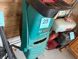 an image of a green and black vacuum cleaner in a garage