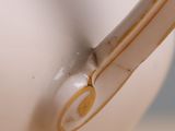 close up of a white tea pot with a gold rim